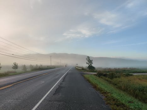 A serene foggy morning scene on a rural road in Middlebury, Vermont.